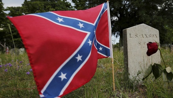 A Confederate battle flag flies next to the grave of a soldier from the Confederate States Army