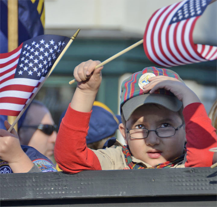 A Scout waves his flag during a parade in Milford last year