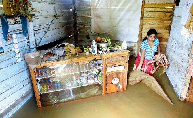 A Sri Lankan woman wades through floodwaters inside her home in Kelaniya yesterday. Pic  AFP