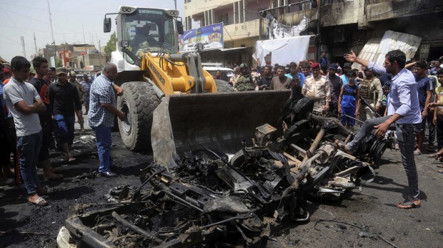 A bulldozer cleans up after the car bomb at a crowded outdoor market in the Iraqi capital's eastern district of Sadr City