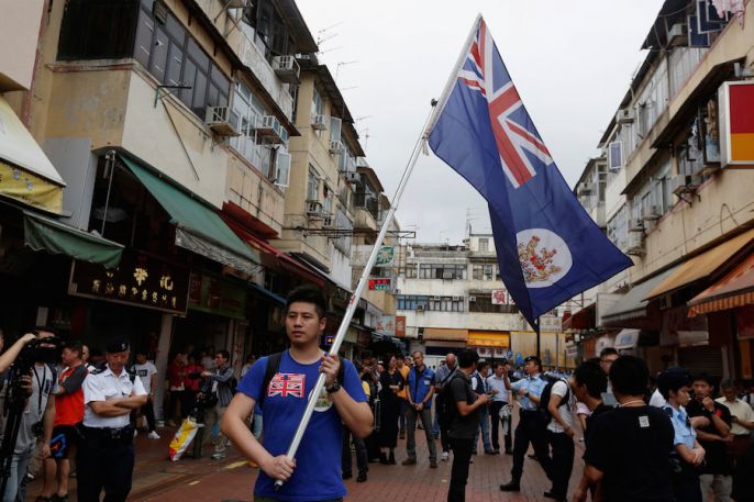 A local protesters against mainland Chinese parallel traders carries a British Hong Kong colonial flag