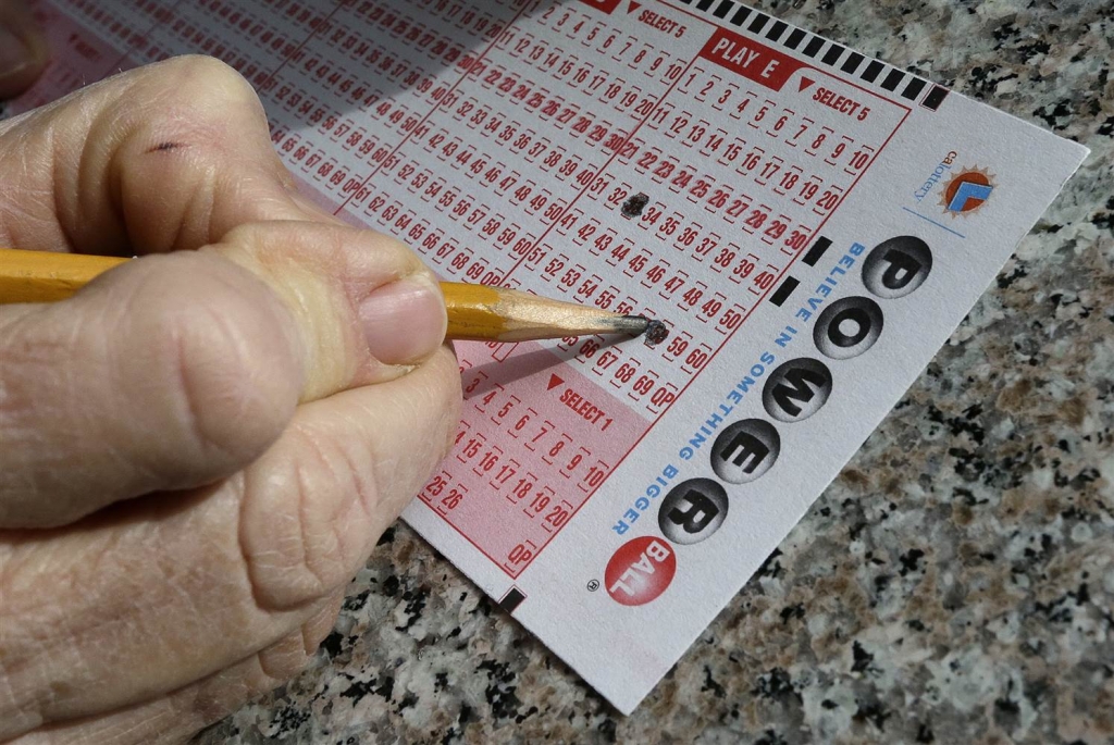 Image A lottery player fills out numbers on a powerball form in Oakland Calif