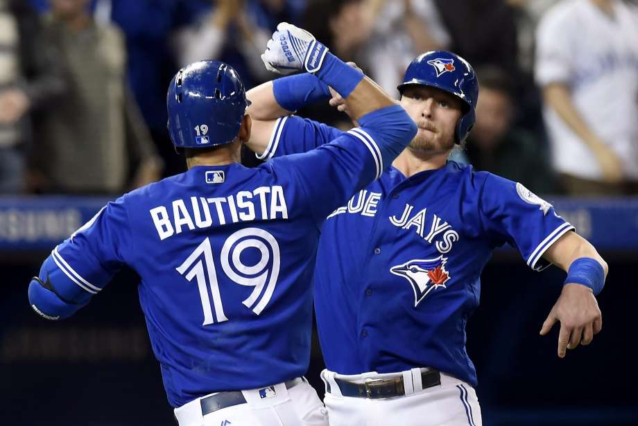 Toronto Blue Jays Josh Donaldson right congratulates teammate Jose Bautista after Bautista's two-run homer during fourth inning baseball action against the Oakland Athletics in Toronto Sunday