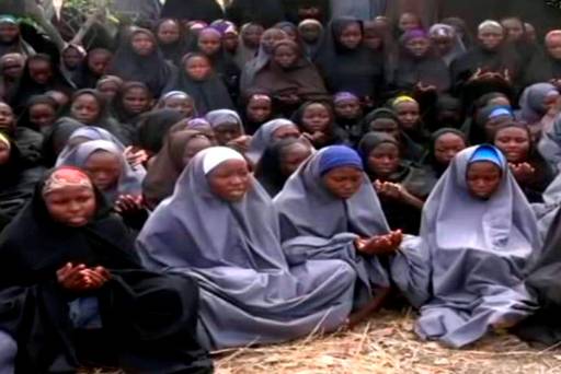 A screengrab taken from a video showing the abducted girls in full-length hijab praying in an undisclosed location