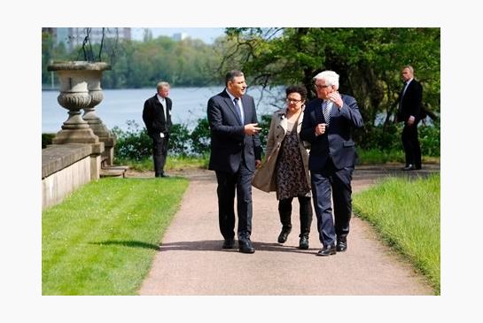 Germany’s Foreign Minister Frank Walter Steinmeier right and Riad Hijab head of the Higher Negotiations Committee the Syrian opposition coalition negotiating in Geneva chat during a joint stroll prior to a meeting of the Foreign Ministers of German