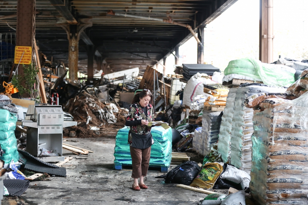 An employee of Urban Garden Center takes stock of damaged