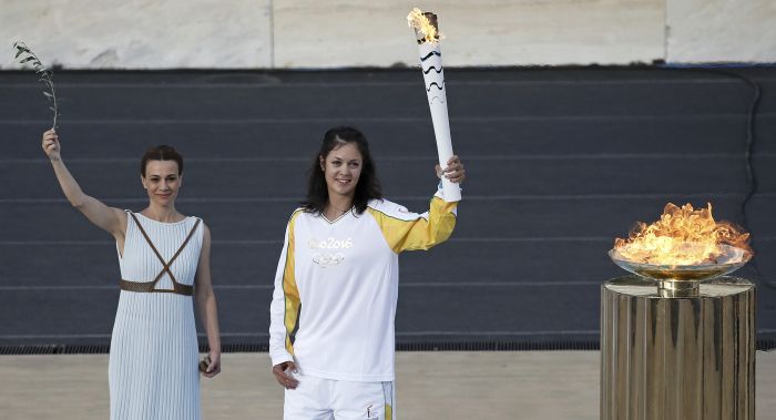 Greek rowing World Champion Katerina Nicolaidou, holds a torch after lighting a cauldron with the Olympic Flame during the handover ceremony of the Olympic Flame to the delegation of the 2016 Rio Olympics at the Panathenaic Stadium in Athens Greece