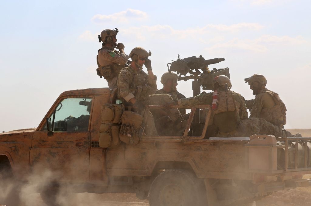 Armed men in uniform identified by Syrian Democratic forces as US special operations forces ride in a pickup truck in the village of Fatisah in the northern Syrian province of Raqa on May 25. /AFP  Delil Souleiman