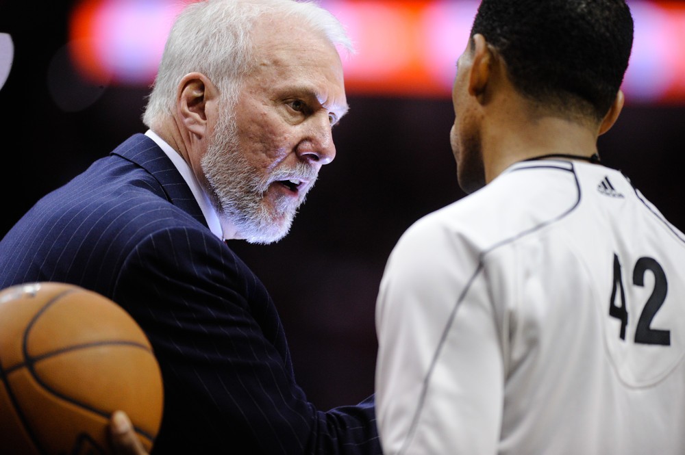 San Antonio Spurs coach Gregg Popovich questions a call with ref Eric Lewis during a game against the Cleveland Cavaliers in the first half of an NBA basketball game Thursday