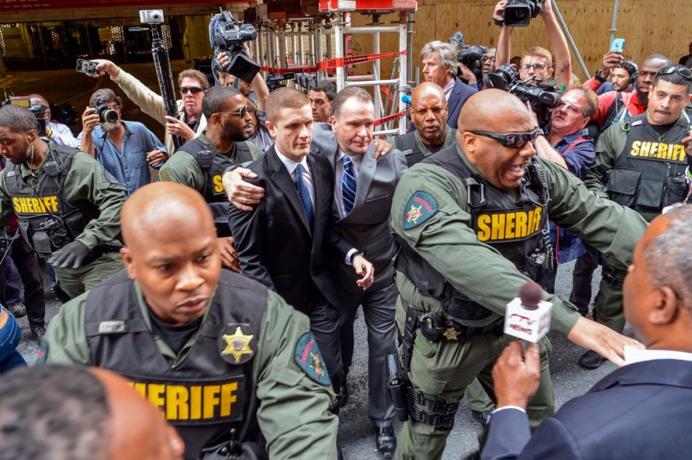 Sheriff deputies escort the family of police officer Edward Nero from the courthouse in Baltimore