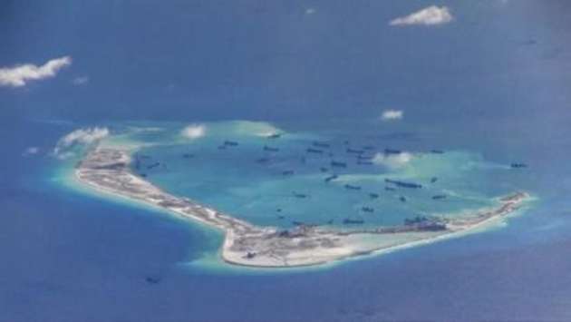 Chinese dredging vessels are purportedly seen in the waters around Mischief Reef in the disputed Spratly Islands in this still image from video taken by a P-8A Poseidon surveillance aircraft provided by the United States Navy