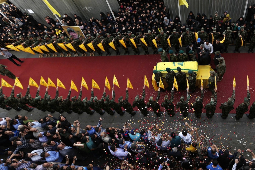 Hezbollah fighters carry the coffin of their slain top commander Mustafa Badreddine draped in a Hezbollah flag who was killed in Syria during his funeral procession in a southern suburb of Beirut Lebanon Friday