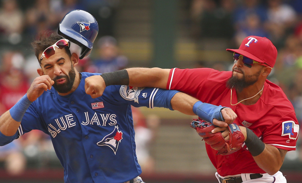 Rangers second baseman Rougned Odor punches Jose Bautista of the Blue Jays after Bautista slid hard into second Sunday. Odor was suspended eight games and Bautista one