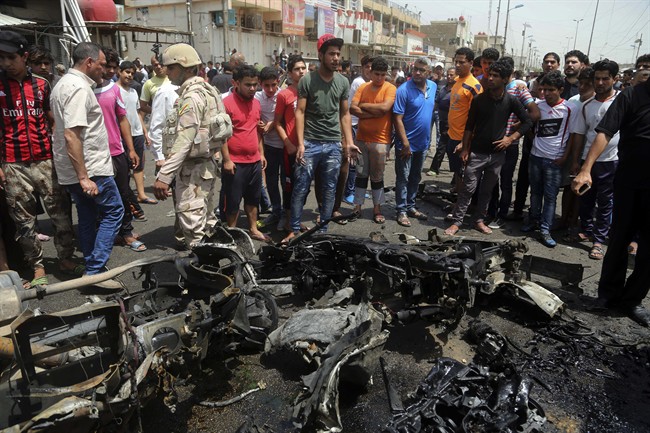 Security forces and citizens inspect the scene after a car bomb explosion at a crowded outdoor market in the Iraqi capital's eastern district of Sadr City Iraq Wednesday