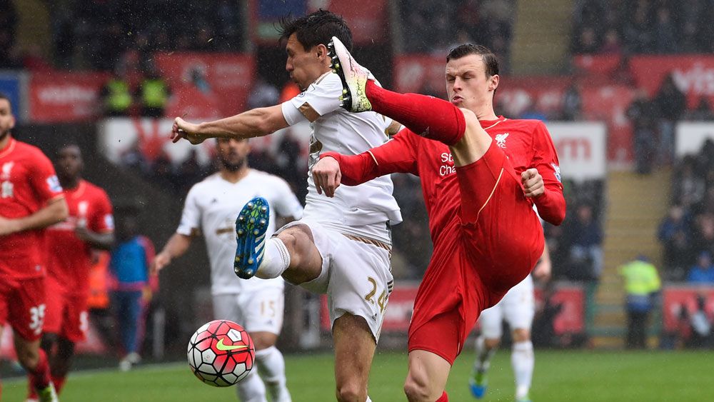 Brad Smith challenges a Swansea player for the ball