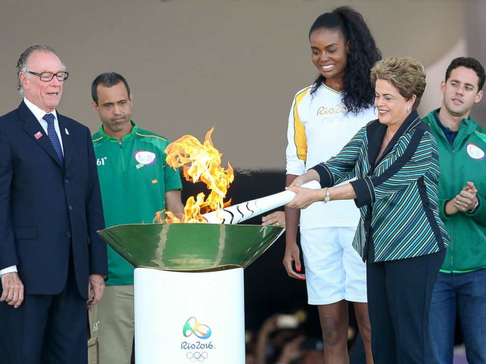 Brazil lights the Olympic torch with Brazilian Olympic Committee Carlos Nuzman left and first torch bearer volleyball player Fabiana Claudino at the Palacio do Planalto