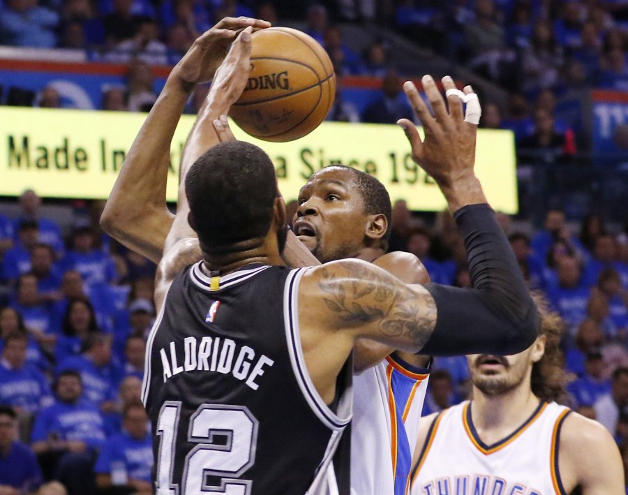 Oklahoma City Thunder forward Kevin Durant center is stopped by San Antonio Spurs forward La Marcus Aldridge in the first quarter of Game 6 of a second-round NBA basketball playoff series in Oklahoma City Thursday