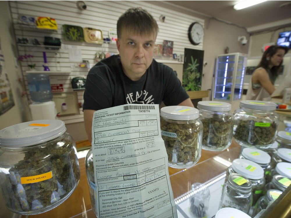 Chuck Varabioff displays a ticket he received from the city for not having a business license. The Pain Society was one of 44 marijuana dispensaries that was ticketed over the weekend. They will stay open despite faci