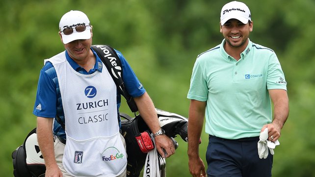 Jason Day walks down the second fairway with his caddie