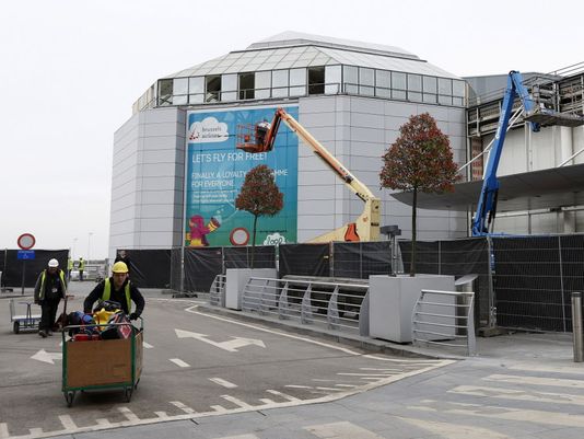 Construction workers wheel equipment as they work at the departures hall at Zaventem Airport in Brussels