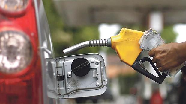 A worker fills a tank at a fuel station in Jakarta