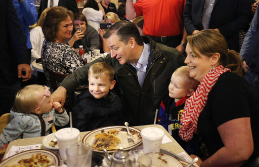 Republican presidential candidate Sen. Ted Cruz R-Texas talks with Elizabeth Craig's children during a visits to the Bravo Cafe during a campaign stop Monday