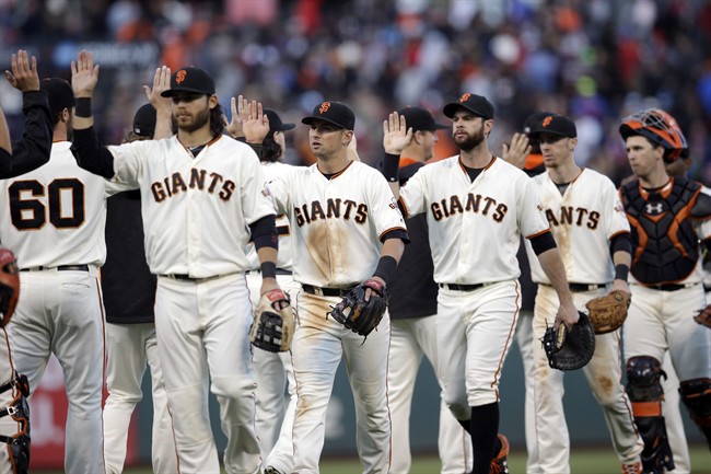 The San Francisco Giants celebrate after a 1-0 win over the Chicago Cubs during a baseball game Sunday