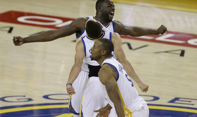 Golden State Warriors forward Draymond Green from top Stephen Curry and Andre Iguodala celebrate after beating the Oklahoma City Thunder in Game 7 of the NBA basketball Western Conference finals in Oakland Calif. Monday