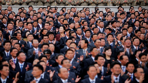 High party and military officials clap hands during a mass rally and parade in the capital's main ceremonial square