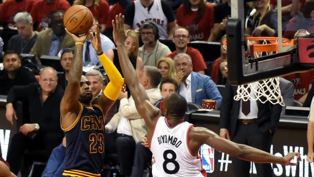 Cleveland Cavaliers forward Le Bron James has a shot blocked by Toronto Raptors center Bismack Biyombo