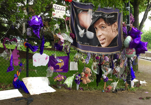 Items left by fans at a memorial for musician Prince hang from a fence outside Paisley Park Wednesday