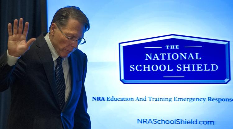 NRA Executive Vice President Wayne La Pierre waves off questions from the media as he walks by a video screen illustratrating the NRA's proposted National School Shield