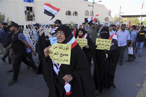 Protesters wave national flags as they cross the al Jumhuriya bridge over Tigris River towards Baghdad's highly fortified Green Zone Iraq. Friday