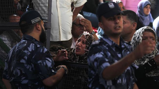 A Palestinian woman argues with a security member as she waits at the Rafah border crossing with Egypt in the southern Gaza Strip after it was opened for two days by Egyptian authorities