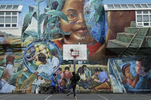 San Francisco International High School students play basketball in the school yard after classes ended at the school in San Francisco. America's schools remain one of the few