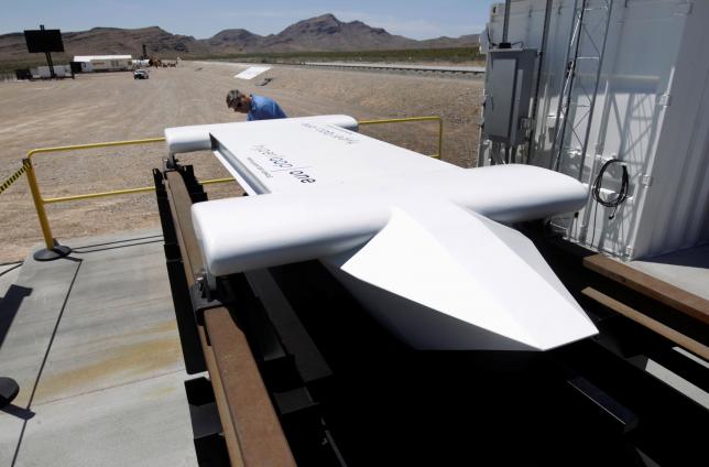 A man looks over a mock-up of a test sled following a propulsion open-air test at Hyperloop One in North Las Vegas Nevada