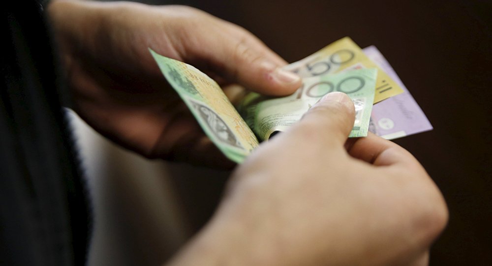 A customer counts his Australian dollar banknotes