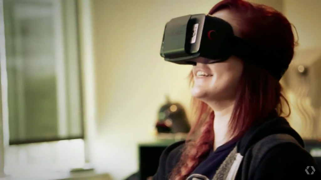 A woman demonstrates a VR video game using a new headset inspired by Google's design