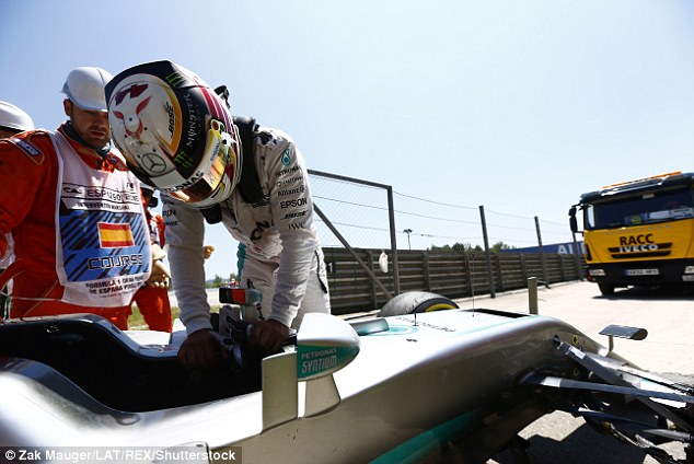 Hamilton stands next to his car after being forced to retire from the Spanish Grand Prix in Barcelona