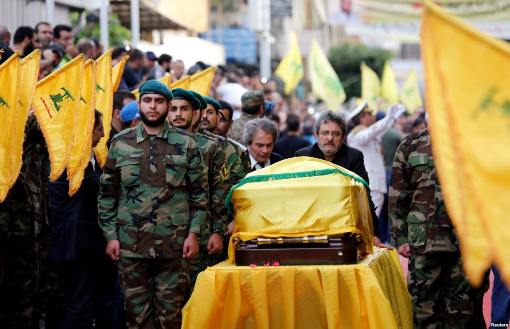 Brothers of top Hezbollah commander Mustafa Badreddine who was killed in an attack in Syria mourn over his coffin during his funeral in Beirut's southern suburbs Lebanon