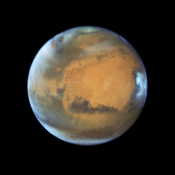 This image shows our neighbouring planet Mars as it was observed shortly before opposition in 2016 by the NASA  ESA Hubble Space Telescope. Some prominent features of the planet are clearly visible the ancient and inactive shield volcano Syrtis Major