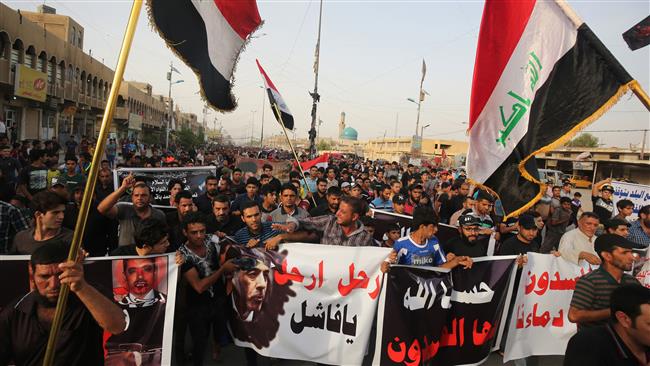 Iraqi protesters carry posters calling for Minister of Interior Mohammed al Ghabban to leave his post after Baghdad blasts