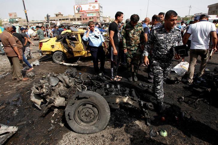 Iraqi security forces and people gather at the site of a car bomb attack in Baghdad's mainly Shi'ite district of Sadr City Iraq