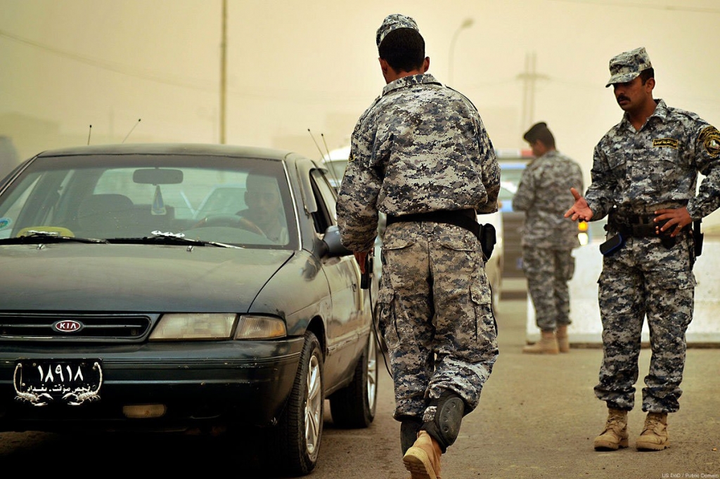 An Iraqi soldeir at a checkpoint using an IDE detector