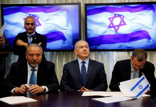 Avigdor Lieberman head of far-right Yisrael Beitenu party  sits next to Israeli Prime Minister Benjamin Netanyahu as they sign a coalition deal to broaden the government's parliamentary majority at the Knesset the Israeli parliament in Jerusale