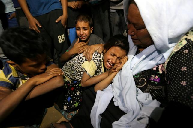 Relatives of Palestinian woman Zena Al Omor whom hospital officials said was killed by fragments of an Israeli tank shell mourn during her funeral in the southern Gaza Strip