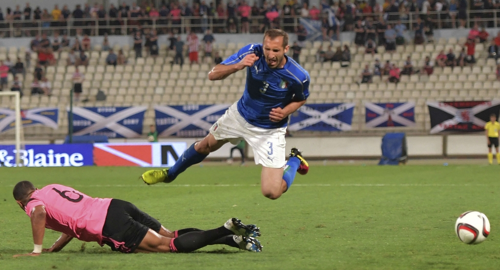 Italy’s Giorgio Chiellini flies over Scotland’s Matt Phillips at the Ta’ Qali stadium in Attard Malta