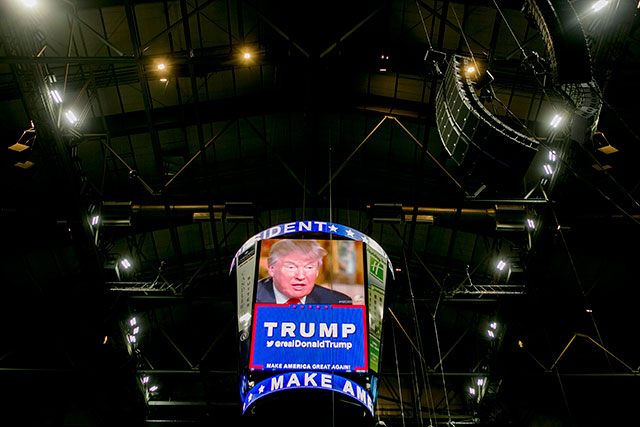 Video ads for Donald Trump run on a digital screen before a rally at the Allen County War Memorial Coliseum in Fort Wayne Ind