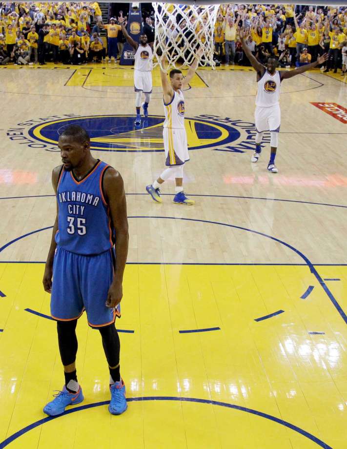 Oklahoma City Thunder's Kevin Durant stands under the basket as the Golden State Warriors celebrate a score during the first half in Game 2 of the NBA basketball Western Conference finals Wednesday