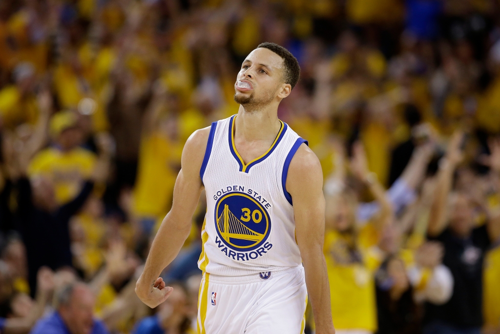 Golden State Warriors guard Stephen Curry reacts after scoring against the Oklahoma City Thunder during the first half of Game 1 of the NBA basketball Western Conference finals in Oakland Calif. Monday